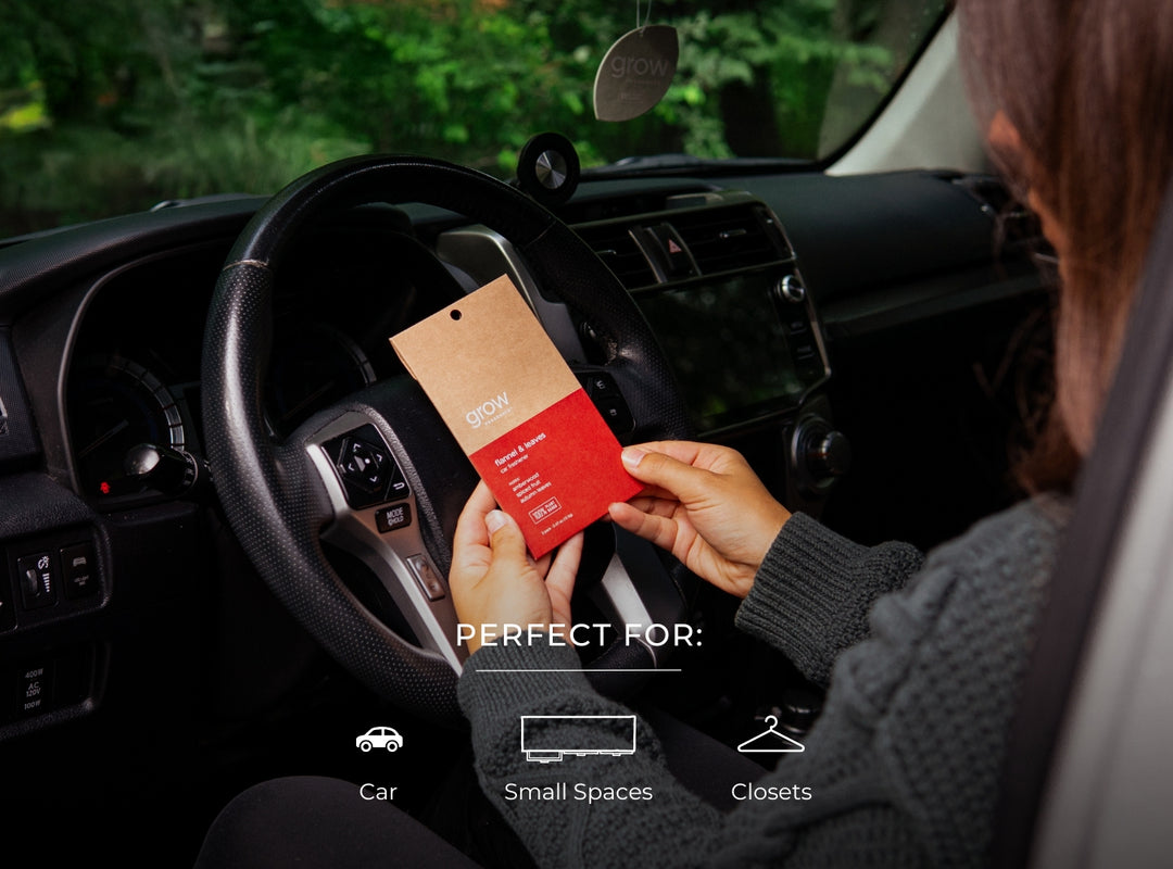 Person holding a car freshener packaging inside a vehicle with text indicating suitability for car, small spaces, and closets.