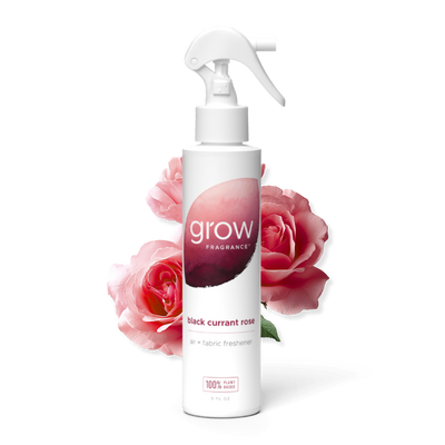 White spray bottle labeled 'grow' with pink roses in the background on a white background
