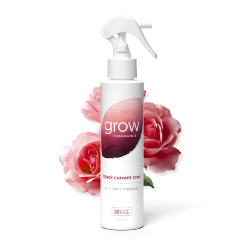 White spray bottle labeled 'grow' with pink roses in the background on a white background