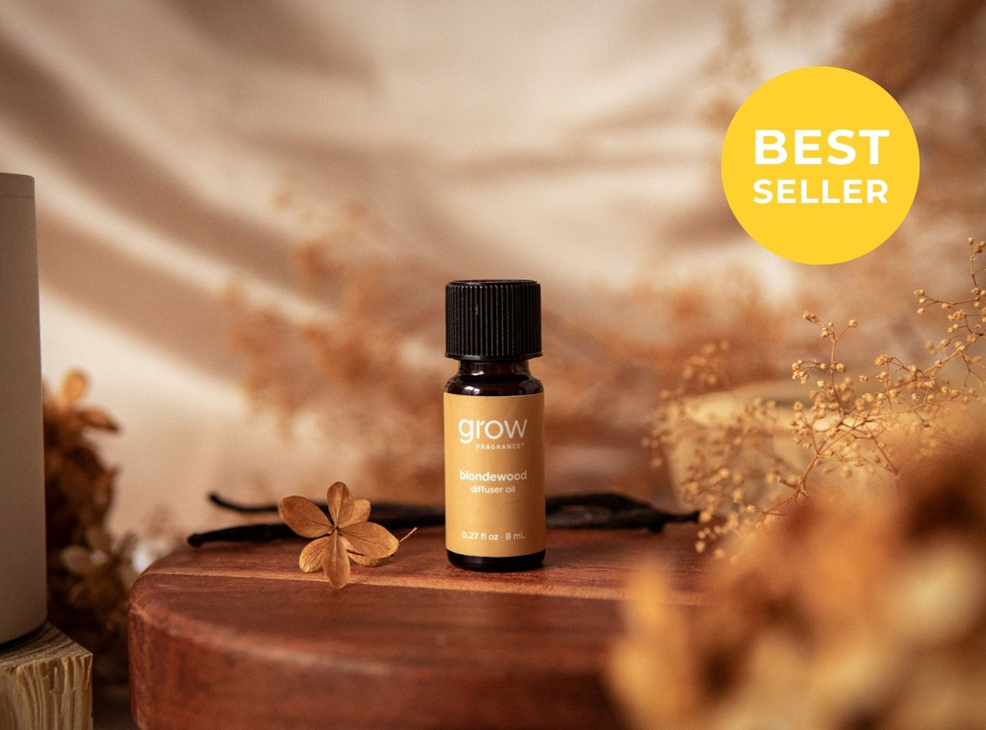 A small amber glass bottle labeled 'grow' with a black cap sits on a round wooden tray, surrounded by dried flowers and warm neutral props. A yellow circular badge in the top right reads 'BEST SELLER'. (featured)