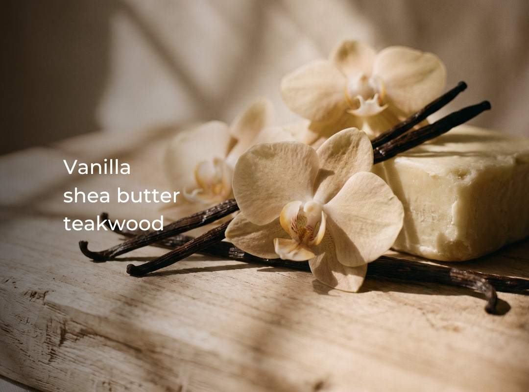 A styled product photo showing a bar of vanilla shea butter next to vanilla beans and cream orchid flowers on a rustic wooden surface, with the text 'Vanilla shea butter teakwood' overlaid on the left. (featured)
