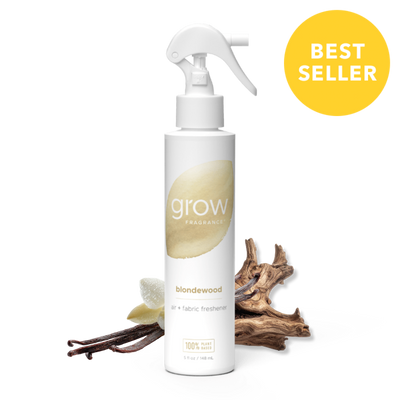White spray bottle labeled 'grow' with blondewood scent, surrounded by wood-like elements on a white background.