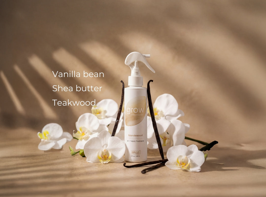 Blondewood bundle White spray bottle with vanilla bean, shea butter, and teakwood text on a wooden surface with white flowers.