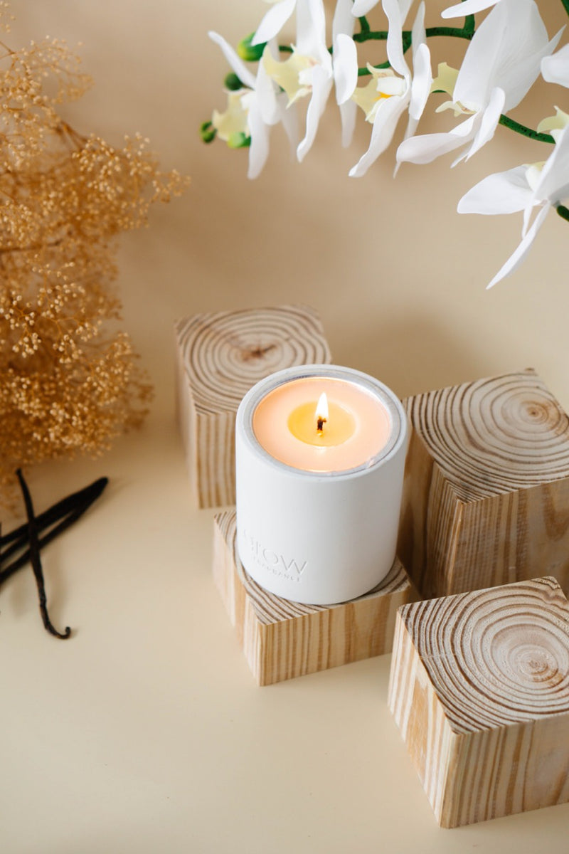 Grow Fragrance non toxic candle on wooden block with white flowers and vanilla beans