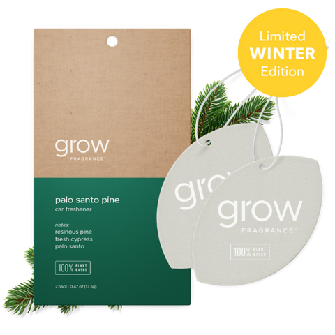 Two oval car air fresheners from grow Fragrance shown in front of their kraft paper and dark green retail card packaging, with pine branches and a yellow 'Limited Winter Edition' badge on a white background.