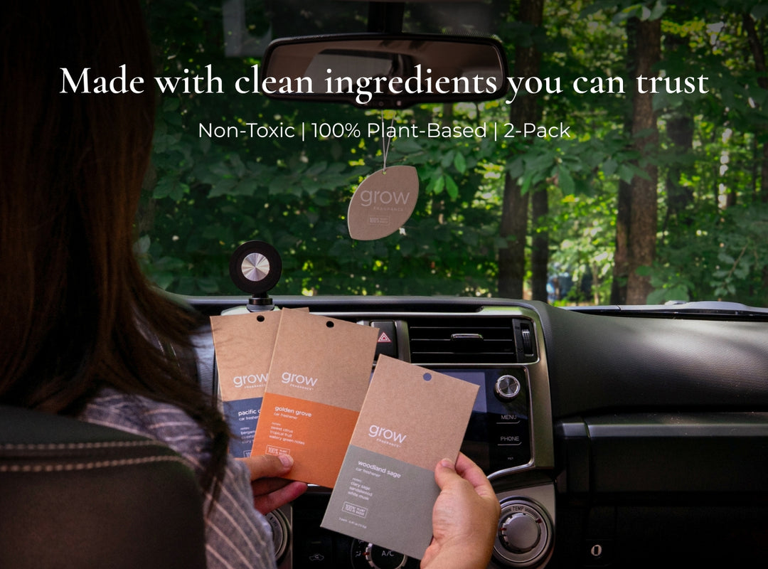 Person holding grow air freshener packages in a car with greenery outside. Text: Made with clean ingredients you can trust. Non-toxic, 100% plant based, 2 pack