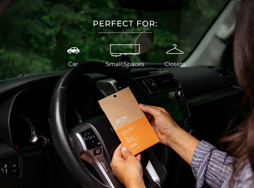 Person holding a Golden Grove Car Freshener inside a car with text indicating suitability for car, small spaces, and closets.
