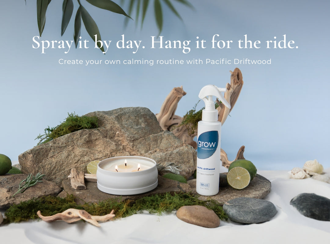 Product display with 'grow' spray bottle, candle, and natural elements on a beach-like setting. Text: Spray it by day. Hang it for the ride. Create your own calming routine with Pacific Driftwood 