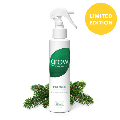 White spray bottle labeled 'grow' with a green leaf logo, surrounded by pine branches on a white background.
