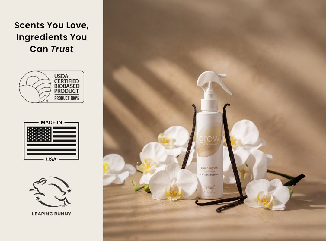 Cosmetic bottle with vanilla beans and flowers on a wooden surface, featuring certification logos on the left.