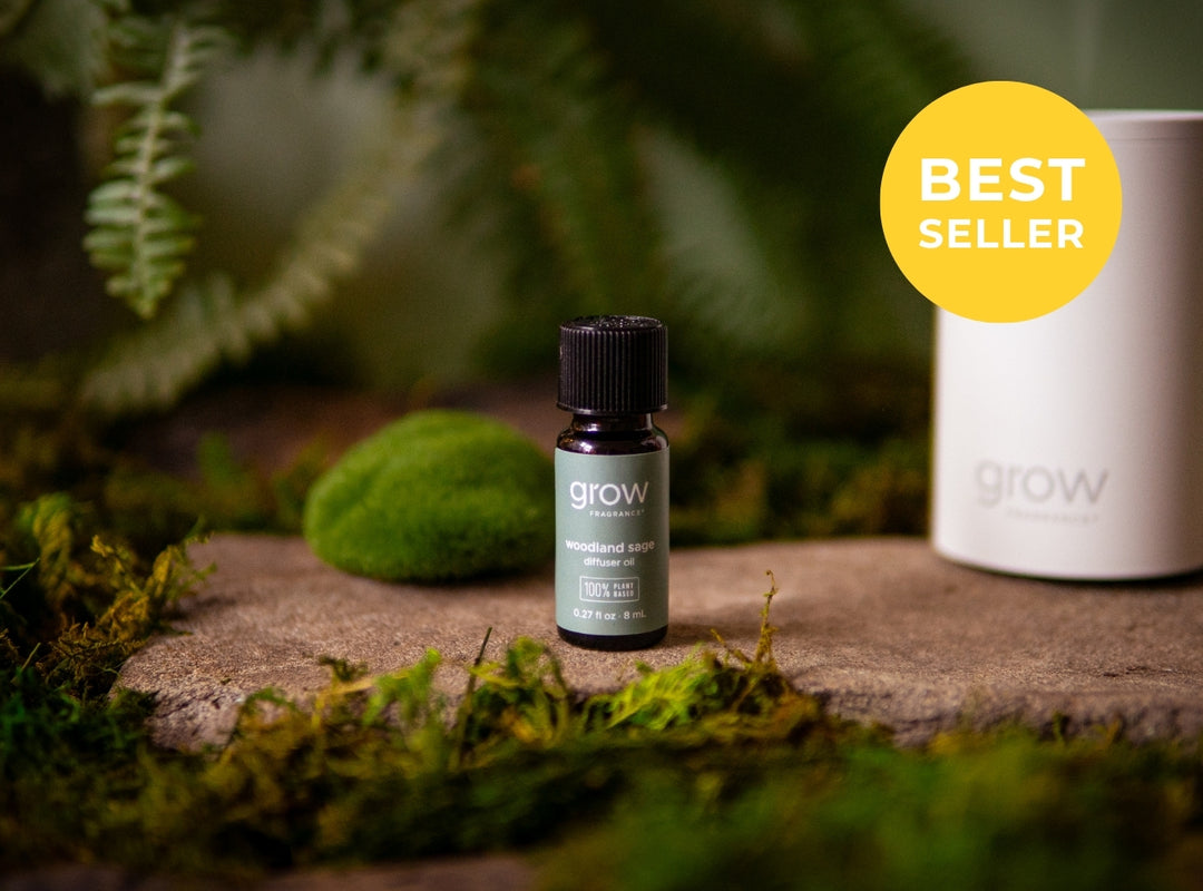 A small dark glass bottle labeled 'grow' with a black cap stands on a stone surface surrounded by moss and greenery. A large white cylindrical container is partially visible behind it, and a yellow circular badge in the top right reads 'BEST SELLER'. (featured)
