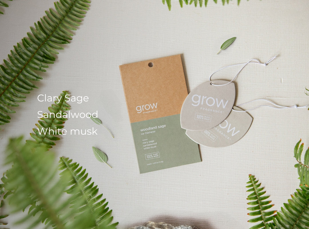 Woodland sage car freshener with 'grow' branding on a light background with green leaves. Scent notes: clary sage, sandalwood, white musk