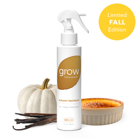 A white spray bottle of Grow Fragrance 'Autumn Heirloom' fabric and air freshener, styled with a small white pumpkin, vanilla beans, and a caramel dessert on a white background with a yellow 'Limited Fall Edition' badge.