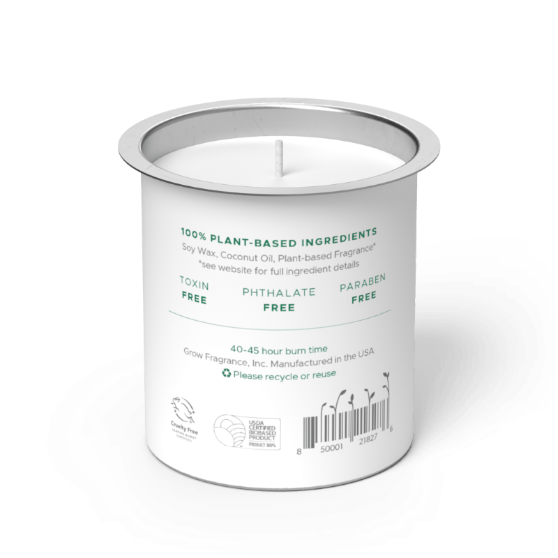 Back label of Grow Fragrance soy candle refill tin, showing 100% plant-based ingredients, toxin-free, phthalate-free, and paraben-free certifications, 40–45 hour burn time, Cruelty Free and USDA Certified Biobased Product seals, and a barcode on a white cylindrical tin with a silver rim. Grow Fragrance, Inc. Manufactured in the USA. 
