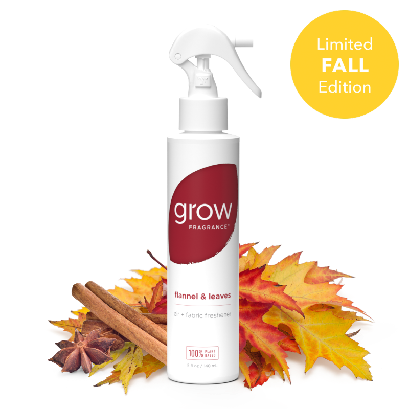 A white spray bottle of grow Fragrance 'flannel & leaves' fabric freshener, styled with autumn leaves and cinnamon sticks on a white background with a yellow 'Limited FALL Edition' badge.
