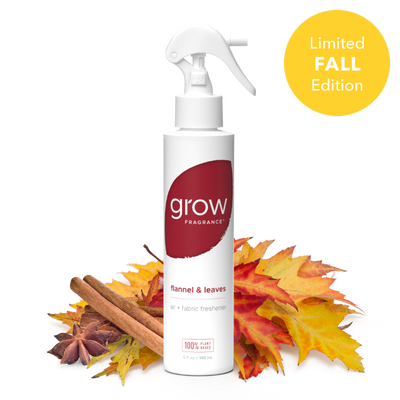 A white spray bottle of grow Fragrance 'flannel & leaves' fabric freshener, styled with autumn leaves and cinnamon sticks on a white background with a yellow 'Limited FALL Edition' badge.