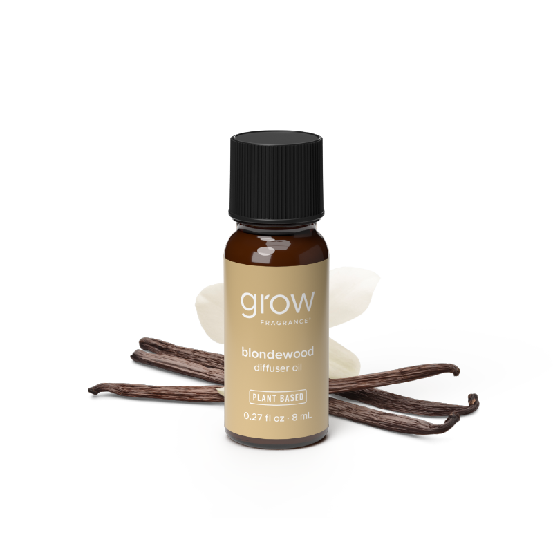 A small amber glass bottle of grow fragrance blondewood diffuser oil with a black cap and tan label, shown on a white background with vanilla beans and a yellow 'BEST SELLER' badge.