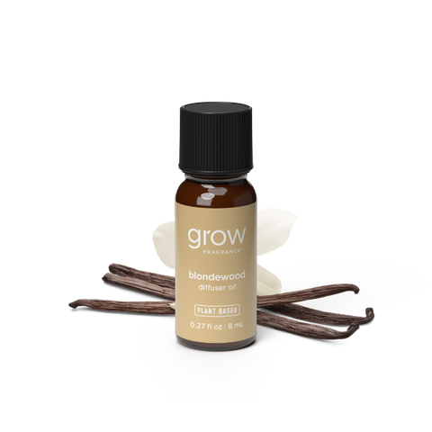 A small amber glass bottle of grow fragrance blondewood diffuser oil with a black cap and tan label, shown on a white background with vanilla beans and a yellow 'BEST SELLER' badge.