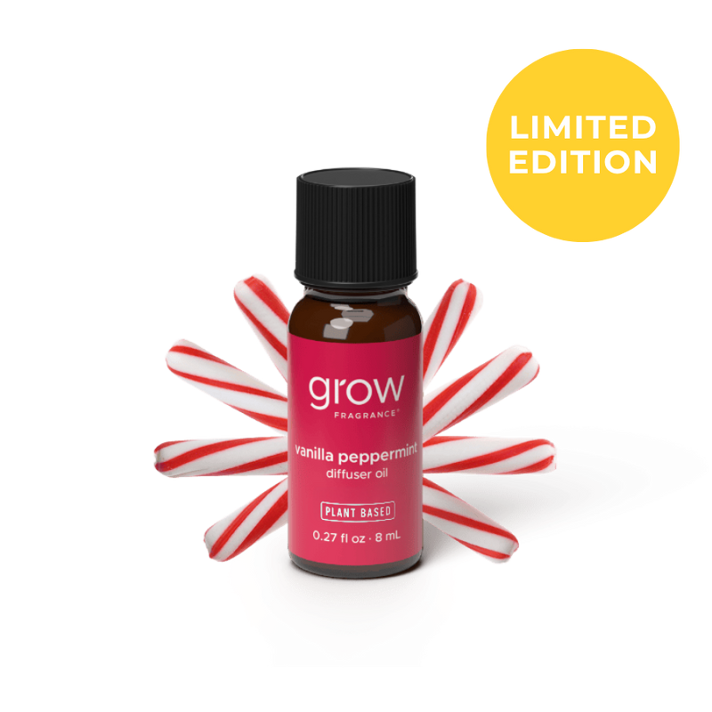 A small amber glass bottle of grow fragrance vanilla peppermint diffuser oil with a black cap and a pink label, styled with red-and-white candy canes behind it on a white background. A yellow circle in the top right says LIMITED EDITION. 