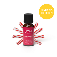 A small amber glass bottle of grow fragrance vanilla peppermint diffuser oil with a black cap and a pink label, styled with red-and-white candy canes behind it on a white background. A yellow circle in the top right says LIMITED EDITION. 