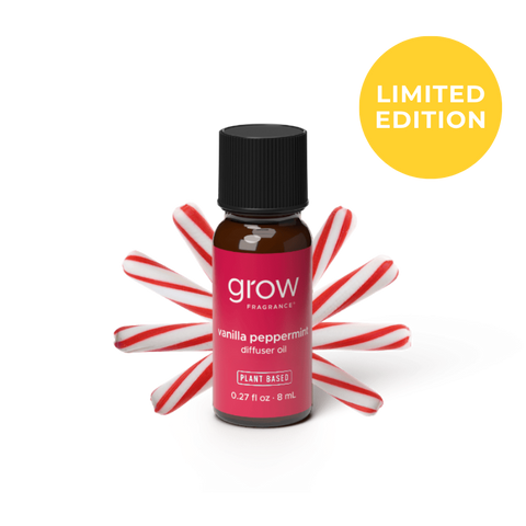 A small amber glass bottle of grow fragrance vanilla peppermint diffuser oil with a black cap and a pink label, styled with red-and-white candy canes behind it on a white background. A yellow circle in the top right says LIMITED EDITION. 