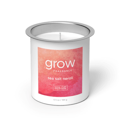 Candle in a metal container with 'grow' fragrance label on a white background